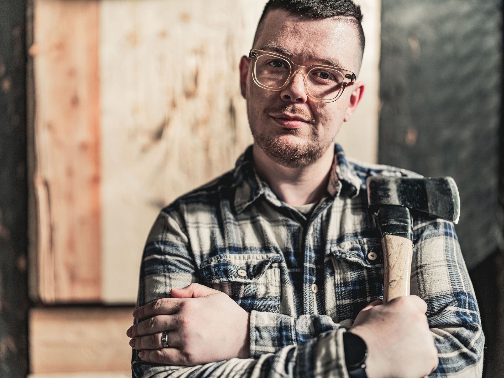 Portrait of young gay man at the axe throwing game room
